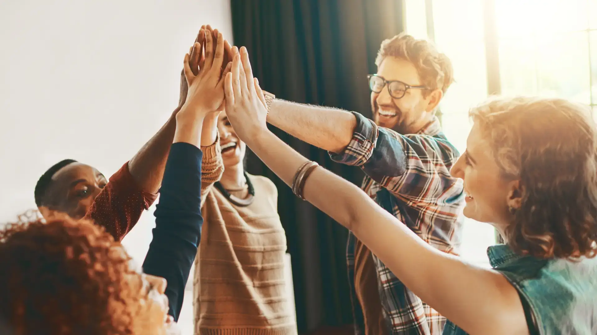 Marketing team placing hands together in the center.